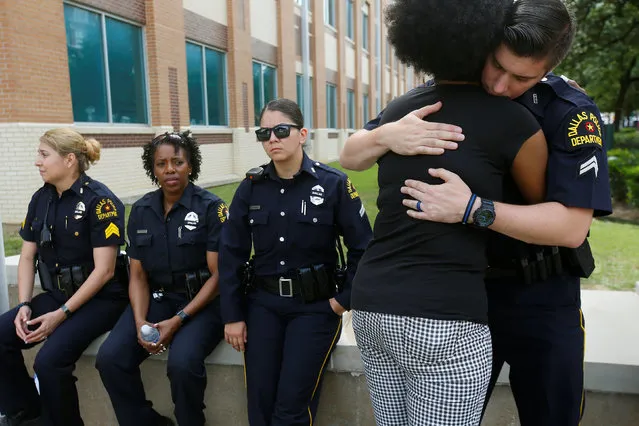 A supporter hugs a Dallas police officer at a makeshift memorial at police headquarters following the multiple police shootings in Dallas, Texas, U.S., July 11, 2016. (Photo by Carlo Allegri/Reuters)