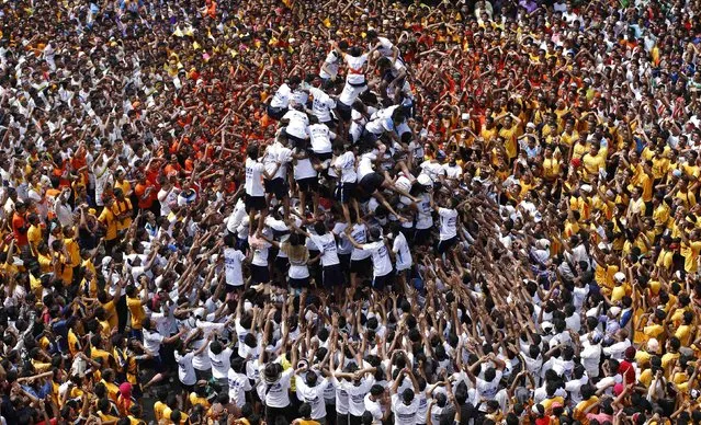 Devotees try to form a human pyramid to break a clay pot containing curd during the celebrations to mark the Hindu festival of Janmashtami in Mumbai August 18, 2014. Janmashtami, which marks the birthday of Hindu god Krishna, is being celebrated across the country today. (Photo by Shailesh Andrade/Reuters)