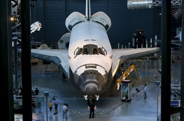 Tourists look at the space shuttle orbiter Discovery on display at the Udvar-Hazy Smithsonian National Air and Space Annex Museum in Chantilly, Virginia August 28, 2015. (Photo by Gary Cameron/Reuters)