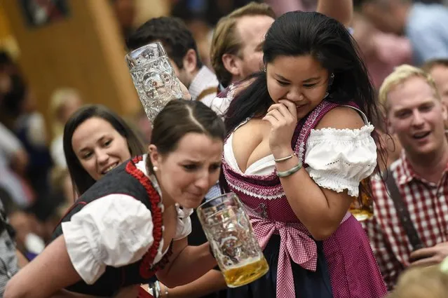 Two female revelers engage in a beer drinking contest in the Hacker Pschorr tent on the first day of the 2017 Oktoberfest beer fest on September 16, 2017 in Munich, Germany. Oktoberfest is the world's largest beer celebration and typically draws over six million visitors over its three-week run. Oktoberfest includes massive beer tents, each run by a different Bavarian brewer, as well as amusement rides and activities. (Photo by Philipp Guelland/Getty Images)