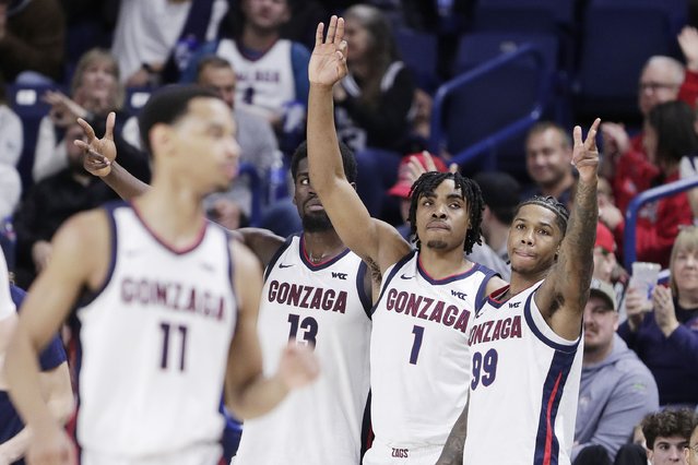 Gonzaga forward Graham Ike (13) along with guards Michael Ajayi (1) and Khalif Battle (99) gesture after a 3-point basket by Nolan Hickman (11) during the second half of an NCAA college basketball game against Bucknell, Saturday, December 21, 2024, in Spokane, Wash. (Photo by Young Kwak/AP Photo)