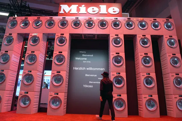 A woman walks underneath an installation of washing machines, at the trade fair stand of German electrical appliance manufacturer Miele to the International Consumer Electronics Fair IFA in Berlin, Germany, September 2, 2015. The fair will take place from 4 to 9 September 2015. (Photo by Rainer Jensen/EPA)