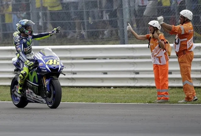 Yamaha MotoGP rider Valentino Rossi of Italy celebrates with track marshals at the end of the San Marino Grand Prix in Misano Adriatico circuit in central Italy, September 13, 2015. (Photo by Max Rossi/Reuters)