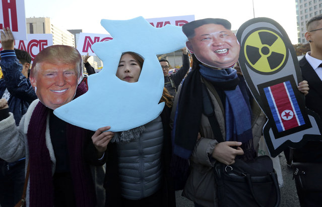 In this file photo taken Sunday, November 5, 2017, anti-war protesters wearing cutouts of U.S. President Donald Trump and North Korean leader Kim Jong Un, march after a rally demanding peace on the Korean peninsula near the U.S. Embassy in Seoul, South Korea. President Donald Trump's agenda in Beijing is expected to be led by the standoff over North Korea's nuclear weapons and demands China do more to balance trade with America. (Photo by Ahn Young-joon/AP Photo)