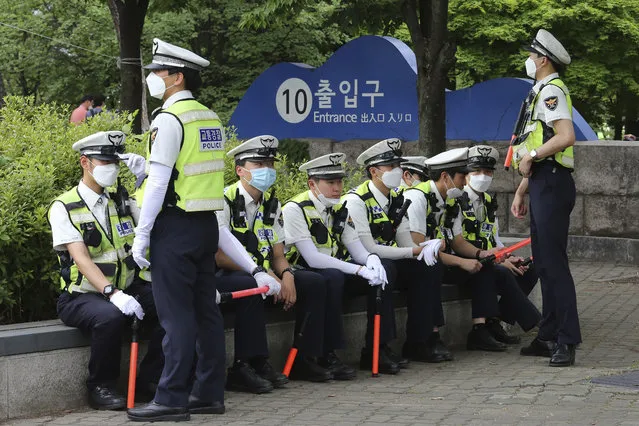 Traffic police officers wearing face masks to help protect against the spread of the new coronavirus take a rest while workers stage a rally against the government's labor policy in Seoul, South Korea, Wednesday, June 10, 2020. (Photo by Ahn Young-joon/AP Photo)