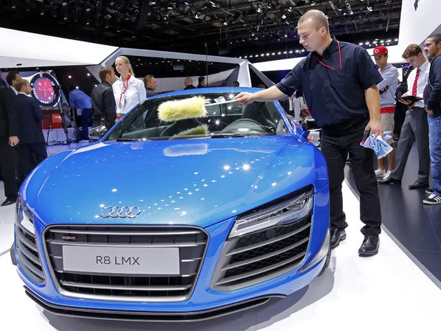 A worker cleans an Audi R8 LMX displayed on media day at the Paris Mondial de l'Automobile, October 2, 2014. (Photo by Jacky Naegelen/Reuters)