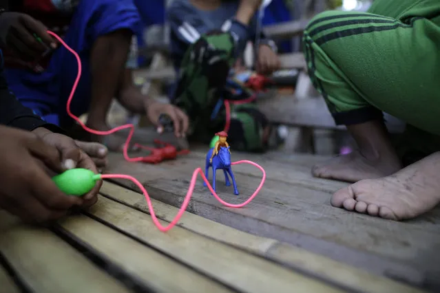 Indonesian child jockeys play with horse toys near the Panda racetrack on the eve of a traditional horse race marking Indonesia's 70th independence anniversary, in Bima, West Nusa Tenggara province, Indonesia, 07 August 2015. (Photo by Mast Irham/EPA)