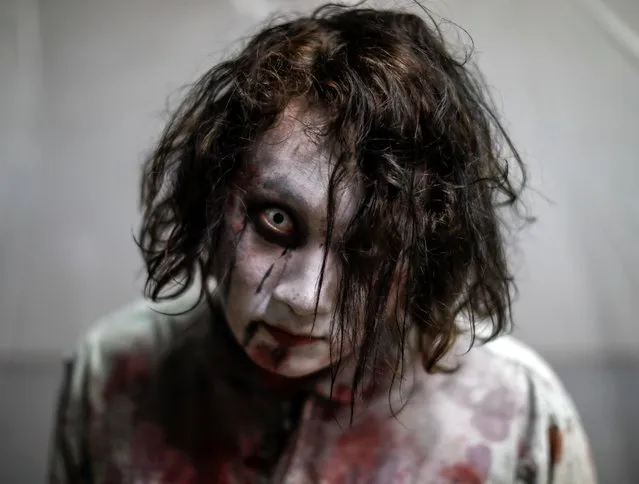 An actor dressed as a zombie is seen before their performance at a drive-in haunted house show by Kowagarasetai (Scare Squad), for people inside a car in order to maintain social distancing amid the spread of the coronavirus disease (COVID-19), at a garage in Tokyo, Japan on July 3, 2020. (Photo by Issei Kato/Reuters)