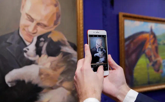 A man takes a picture of a painting depicting Russian president Vladimir Putin at the “SUPERPUTIN” exhibition at UMAM museum in Moscow, Russia on December 6, 2017. (Photo by Maxim Shemetov/Reuters)