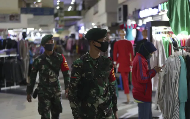 Indonesian soldiers wearing face mask patrol amid fears of the new coronavirus outbreak at a market in Jakarta, Indonesia Tuesday, June 30, 2020. (Photo by Achmad Ibrahim/AP Photo)