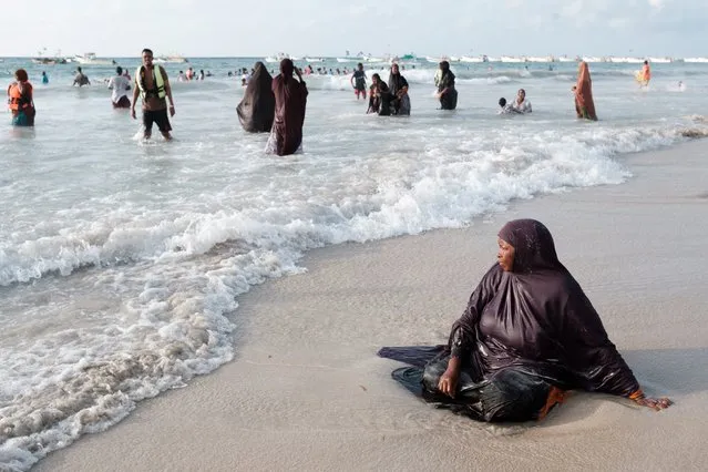 A women sits in the waters break at Lido beach early in the morning in Mogadishu, Somalia on November 11, 2022. (Photo by Guy Peterson/AFP Photo)