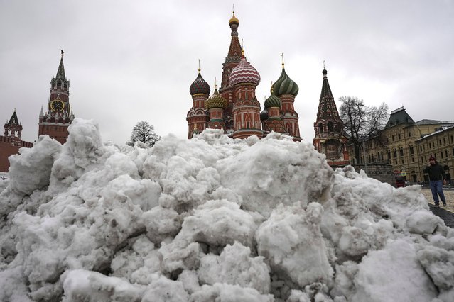 The St. Basil's Cathedral, center, and the Spasskaya Tower, left, are seen behind a pile of cleared snow after overnight snowfall in Red Square in Moscow, Russia, Monday, April 7, 2025. (Photo by Alexander Zemlianichenko/AP Photo)