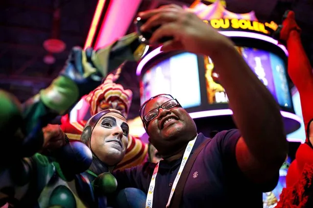 Vander McInnis, right, of Snoqualmie, Wash., takes a selfie with Cirque du Soleil performers at the Scientific Games booth during the Global Gaming Expo on Tuesday, September 29, 2015, in Las Vegas. The convention, geared for the gaming industry, runs through Oct. 1. (Photo by John Locher/AP Photo)