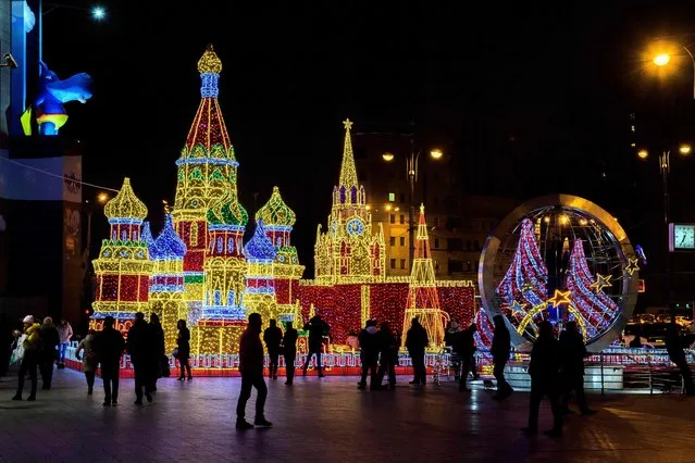Visitors walk in front of an illuminated replica of The Kremlin and St. Basil Cathedral built for the forthcoming holiday season outside a shopping mall in Moscow on November 24, 2017. (Photo by Mladen Antonov/AFP Photo)