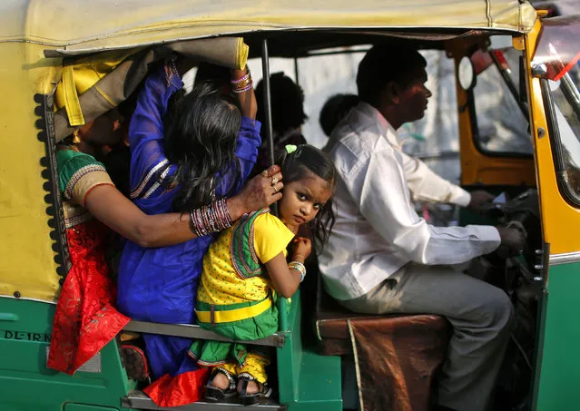 A girl peeps out from an auto rickshaw as she arrives with her family to worship the Sun god Surya during the Hindu religious festival of Chatt Puja in New Delhi October 29, 2014. (Photo by Anindito Mukherjee/Reuters)