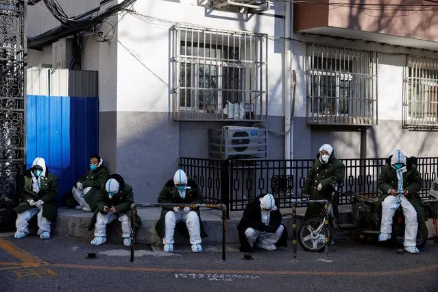Pandemic control workers in protective suits sit in a neighbourhood that used to be under lockdown, as coronavirus disease (COVID-19) outbreaks continue, in Beijing, China on December 10, 2022. (Photo by Thomas Peter/Reuters)