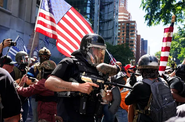 A member of the Proud Boys fires a paint ball gun into a crowd of anti-police protesters as the two sides clashed on August 22, 2020 in Portland, Oregon. For the second Saturday in a row, right wing groups gathered in downtown Portland, sparking counter protests and violence. (Photo by Nathan Howard/Getty Images)