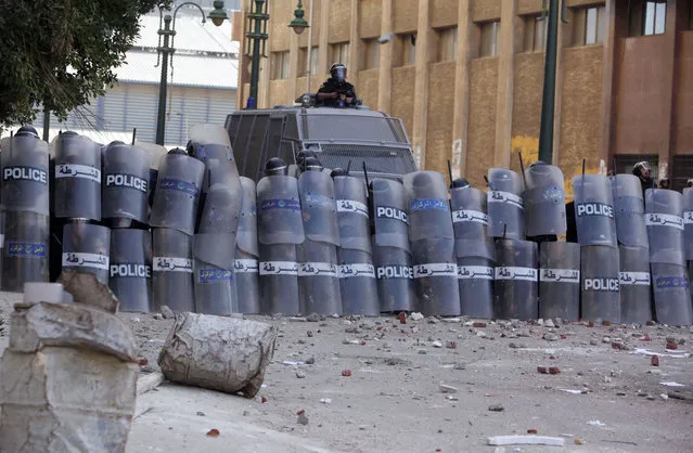 Police take cover as protesters throw stones at them during clashes in Alexandria, on January 25, 2013. (Photo by Asmaa Waguih/Reuters/The Atlantic)