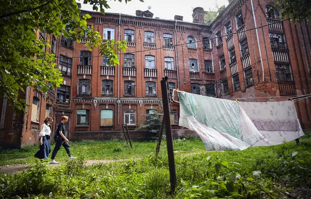 People walk past one of the buildings of a dormitory for the workers of Proletarka textile factory in the town of Tver, 200 kilometres north-west from Moscow on August 8, 2020. (Photo by Andrey Borodulin/AFP Photo)