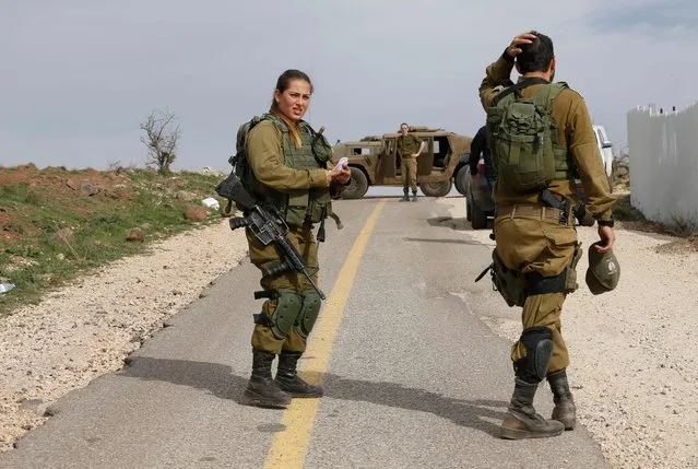 Israeli soldiers block a road in the Israeli-annexed Golan Heights, on February 10, 2018. Israel struck a dozen Syrian and Iranian targets inside Syria in “large-scale” raids after an Israeli fighter jet crashed under fire from Syrian air defences in a severe increase in tensions, the military said. (Photo by Jalaa Marey/AFP Photo)