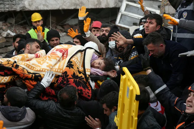Rescuers carry out a girl from a collapsed building following an earthquake in Diyarbakir, Turkey on February 6, 2023. (Photo by Sertac Kayar/Reuters)
