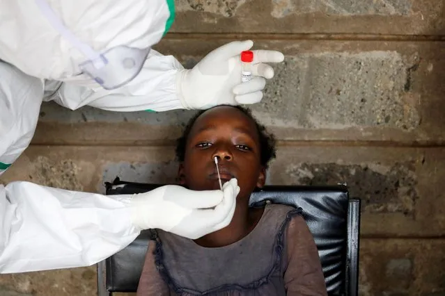 A health worker collects a swab sample from a young girl during free mass testing for the coronavirus disease (COVID-19) in Kibera slums of Nairobi, Kenya, October 17, 2020. (Photo by Baz Ratner/Reuters)