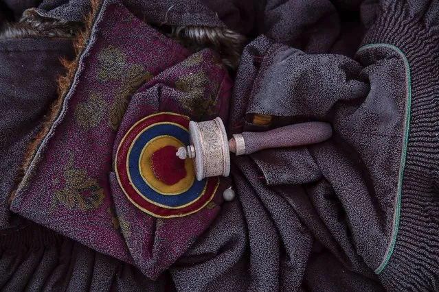 Frost remains on a prayer wheel, traditional Tibetan hat and monks robes as people gather in sub zero temperature at Buddhist laymen lodge for morning chanting session during the Utmost Bliss Dharma Assembly, the last of the four Dharma assemblies at Larung Wuming Buddhist Institute in remote Sertar county, Garze Tibetan Autonomous Prefecture, Sichuan province, China November 1, 2015. (Photo by Damir Sagolj/Reuters)