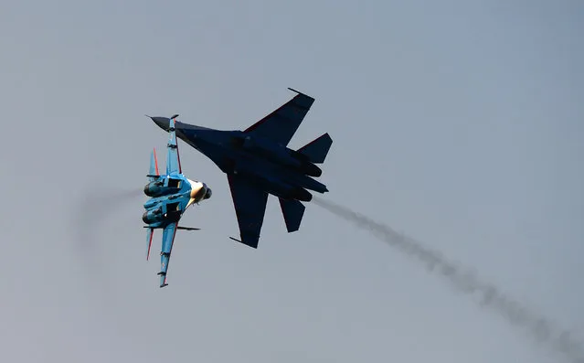 Members of the Russian Air Force perform with their Su-27 type aircraft during the International Air Show at the Hungarian Air Force base in Kecskemet, southern Hungary, on August 3, 2013. (Photo by Attila Kisbenedek/AFP Photo)