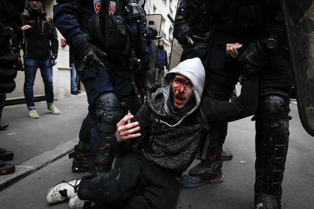 Riot police officers detain a protester during a students demonstration, Thursday, March 22, 2018 in Paris. Nationwide strikes are causing major disruptions to trains, planes, schools and other public services in France Thursday as unions set up dozens of street protests across the country. (Photo by AFP Photo/Stringer)