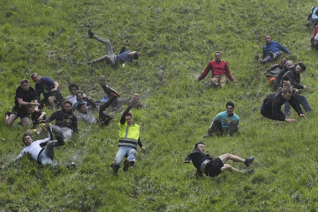 Participants take part in the annual cheese rolling at Cooper's Hill in Brockworth, Gloucestershire, UK on Monday, May 27, 2024. The traditional event attracts people from around the globe who come to chase a 7lb Double Gloucester cheese down the steep Coopers Hill. (Photo by Jacob King/PA Images via Getty Images)