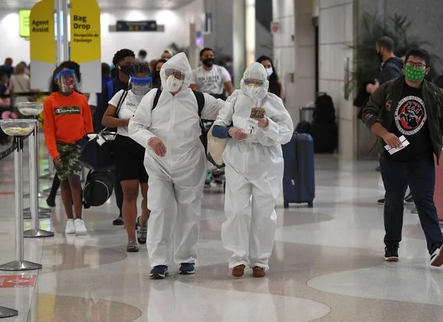 Airline passengers Eli and Maria are seen wearing Hazmat Suits at Fort Lauderdale Hollywood International Airport in Miami are traveling for Thanksgiving eve November 25, 2020 as U.S. coronavirus cases soar toward 200,000 a day. The US centers for Disease control and Prevention warnings to avoid holiday travel as COVID-19 cases are surging across the United States. Millions of American travelers ignored guidance from CDC last week urging them not to travel for the holidays. (Photo by Larry Marano/Rex Features/Shutterstock)
