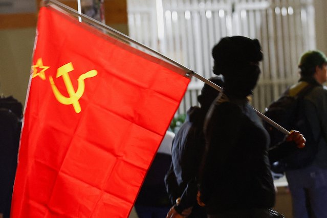 A person carries a Soviet flag near the ICE headquarters in PPortland, Oregon, U.S., October 4, 2025. (Photo by John Rudoff/Reuters)