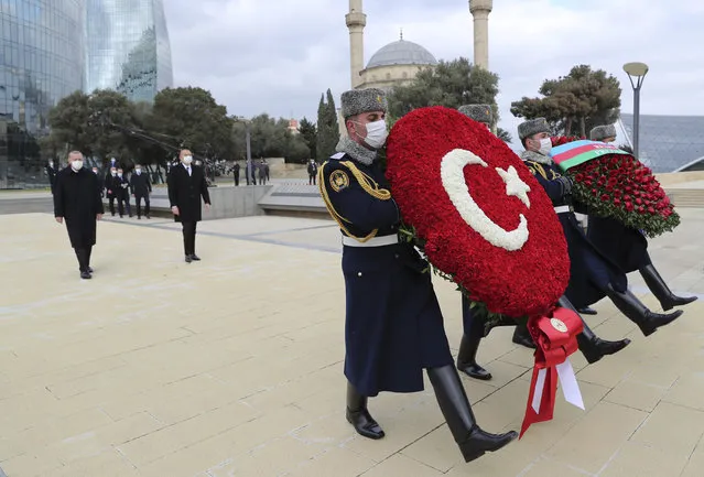 Turkey's President Recep Tayyip Erdogan, left and Azerbaijan's President Ilham Aliyev, center, attend a wreath laying ceremony at the Honorary Alley and the Alley of Martyrs in Baku, Azerbaijan, Thursday, December 10, 2020. The parade was held in celebration of the peace deal with Armenia over Nagorno-Karabakh, with Turkey being a strong supporter of Azerbaijan.(Photo by Turkish Presidency via AP Photo, Pool)