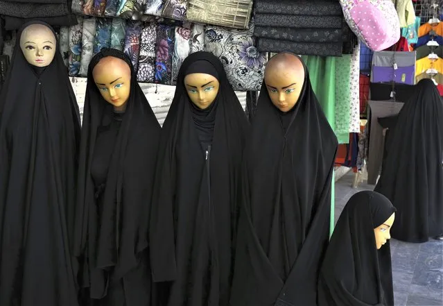 Mannequins dressed with Chador are displayed at a shop in front of the Fatima Masumeh Shrine at the city of Qom, some 80 miles (125 kilometers) south of the capital Tehran, Iran, Tuesday, FFebruary 7, 2023. (Photo by Vahid Salemi/AP Photo)