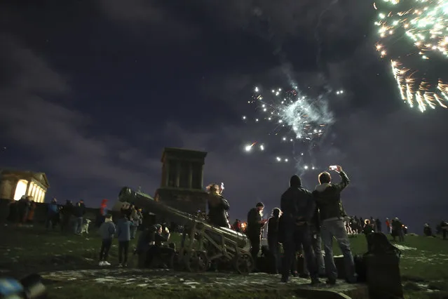People on Calton Hill watch fireworks in Edinburgh as people are urged to avoid Hogmanay celebrations in the midst of tough coronavirus restrictions Thursday December 31, 2020. (Photo by Andrew Milligan/PA Wire via AP Photo)