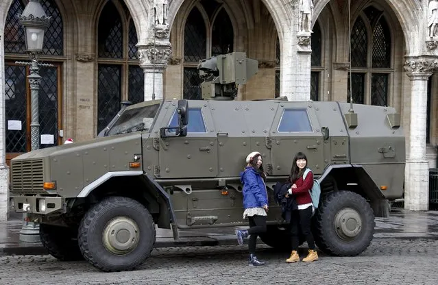 Tourists pose in front of a military armoured vehicle parked at Brussels Grand Place, November 22, 2015, after security was tightened in Belgium following the fatal attacks in Paris. (Photo by Francois Lenoir/Reuters)