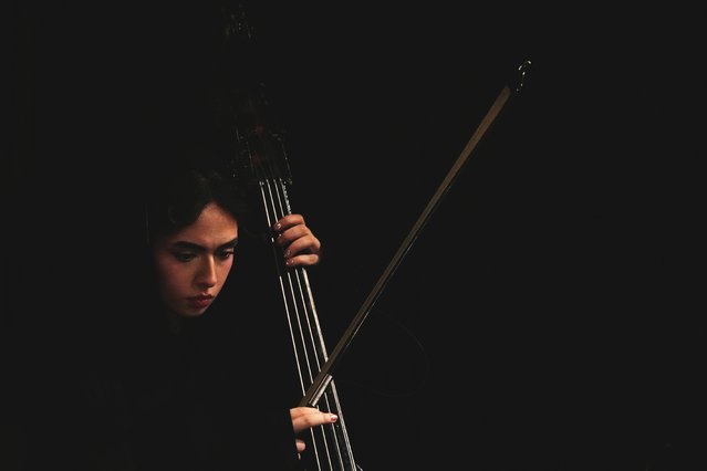 A musician plays her instrument as Paniz Faryousefi became the first woman to conduct a performance of the Tehran Symphony Orchestra at Unity Hall in Tehran, Iran, November 12, 2025. (Photo by Vahid Salemi/AP Photo)