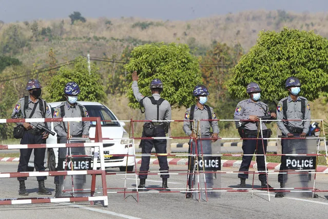 Policemen wearing protective face mask stand guard behind a road barricade, as a part of security preparations ahead of next week's opening of Myanmar's parliament in Naypyitaw, Myanmar, Friday, January 29, 2021. Myanmar's election commission rejected allegations by the military that fraud played a significant role in determining the outcome of November's elections, which delivered a landslide victory to Aung San Suu Kyi's ruling party. (Photo by Aung Shine Oo/AP Photo)