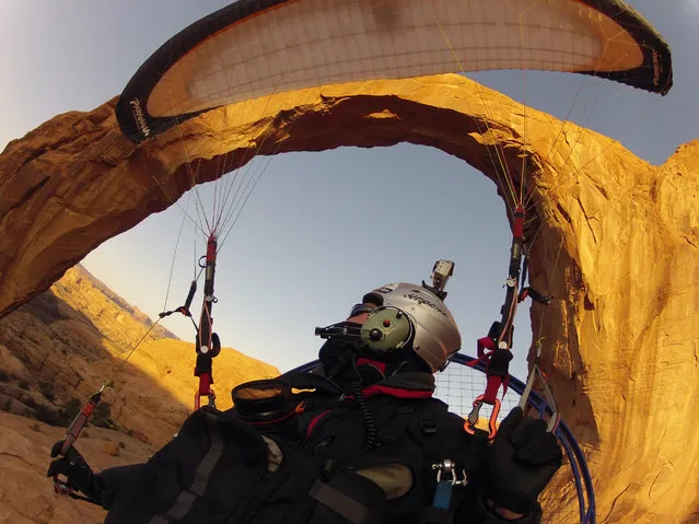 “Flying Through the Arch”. A paramotor pilot flies through the Corona Arch near Moab, Utah. This daring feat was captured with a GOPRO Hero 2 camera and made possible by the incredible flying machine called the Paramotor. (Photo and caption by Glenn Tupper/National Geographic Traveler Photo Contest)