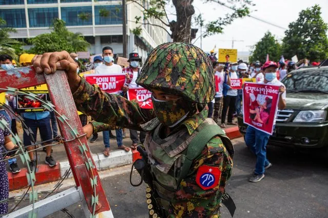 A soldier moves a barricade as troops stand outside the Central Bank of Myanmar during a protest against the military coup, in Yangon, Myanmar, February 15, 2021. (Photo by Reuters/Stringer)