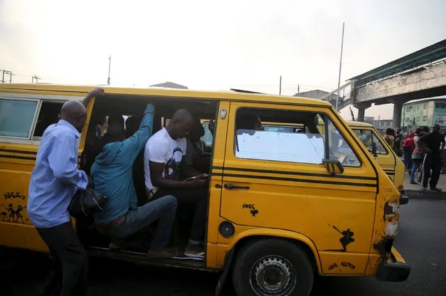 A commuter tries to get into a commercial  bus in Ojota in Nigeria's commercial capital Lagos November 23, 2015. (Photo by Akintunde Akinleye/Reuters)
