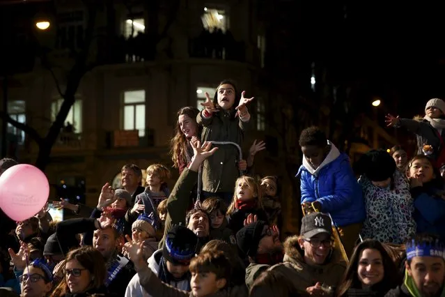 Children react as they try to get sweets thrown at them during the traditional Epiphany parade in Madrid, Spain, January 5, 2016. (Photo by Susana Vera/Reuters)