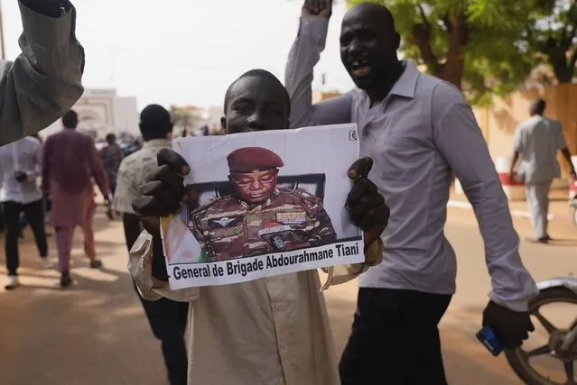 Nigeriens participate in a march called by supporters of coup leader Gen. Abdourahmane Tchiani, pictured, in Niamey, Niger, Sunday, July 30, 2023. Days after after mutinous soldiers ousted Niger's democratically elected president, uncertainty is mounting about the country's future and some are calling out the junta's reasons for seizing control. (Photo by Sam Mednick/AP Photo)
