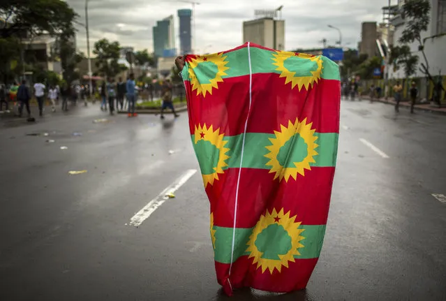 A man holds an Oromo Liberation Front (OLF) flag as hundreds of thousands of Ethiopians gathered to welcome returning leaders of the once-banned group in the capital Addis Ababa, Ethiopia Saturday, September 15, 2018. (Photo by Mulugeta Ayene/AP Photo)
