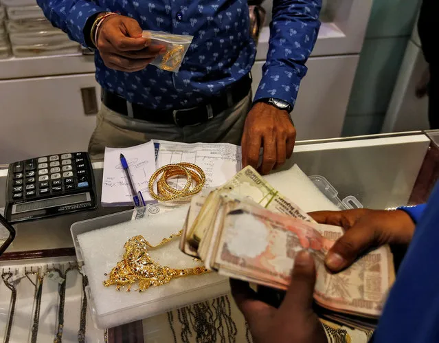 A customers pays after buying gold ornaments at a jewellery showroom during Dhanteras, a Hindu festival associated with Lakshmi, the goddess of wealth, in Mumbai, India October 28, 2016. (Photo by Danish Siddiqui/Reuters)