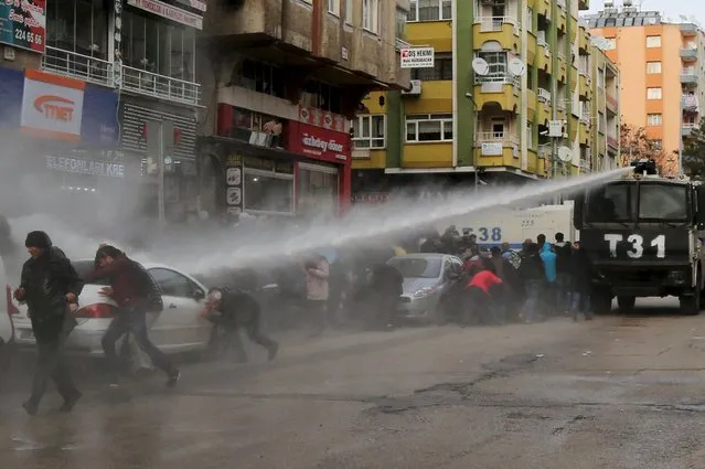 Turkish riot police use a water cannon to disperse Kurdish demonstrators during a protest against a curfew in Sur district and security operations in the region, in the southeastern city of Diyarbakir, Turkey January 17, 2016. (Photo by Sertac Kayar/Reuters)