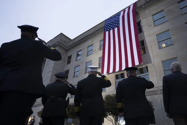 First responders salute as an American flag is unfurled at the Pentagon at sunrise to commemorate the 2001 terrorist attack on the Pentagon, during an observance ceremony, Monday morning, September 11, 2023, in Washington. (Photo by Manuel Balce Ceneta/AP Photo)