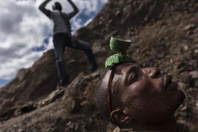 A “creuseur”, or digger, a plastic lantern on his head, readies to enter a copper and cobalt mine in Kawama, Democratic Republic of Congo on June 8, 2016. Cobalt is used in the batteries for electric cars and mobile phones. Working conditions are dangerous, often with no safety equipment or structural support for the tunnels. The diggers say they are paid on average US$2-3/day. (Photo by Michael Robinson Chavez/The Washington Post)