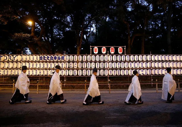 Shinto priests walk past lanterns after attending a ritual to usher in the upcoming New Year at the Meiji Shrine in Tokyo, Japan, December 31, 2016. (Photo by Kim Kyung-Hoon/Reuters)