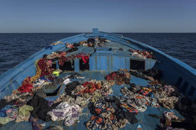A wooden boat used by 450 refugees and migrants, mostly from Eritrea, remains abandoned off the Libyan coast after they were rescued by aid workers of the Spanish NGO Proactiva Open Arms, 34 miles north of Kasr-El-Karabulli, Libya, on Tuesday January 16, 2018. (Photo by Santi Palacios/AP Photo)